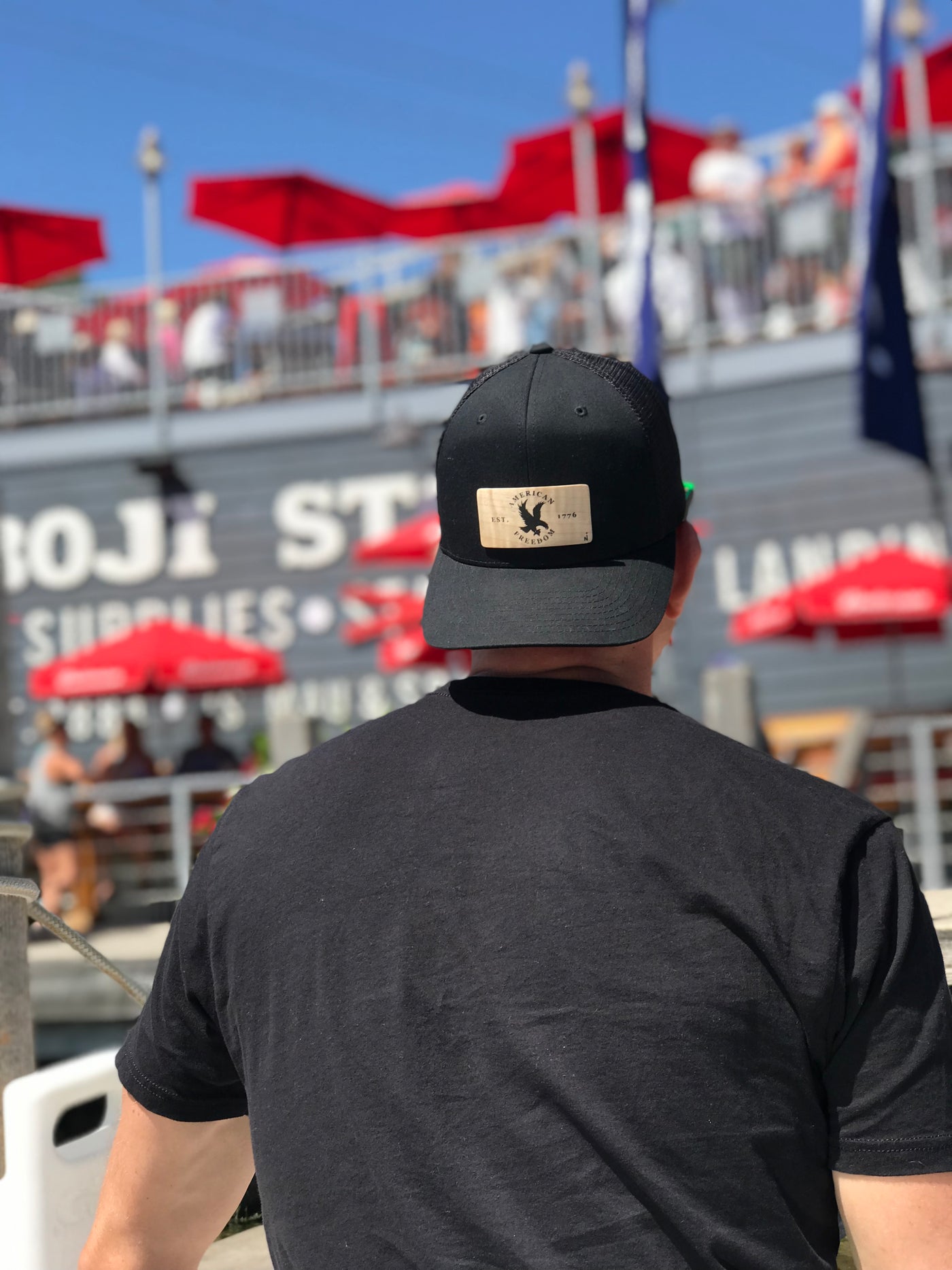 Person wearing a true North wooden plank hat near the water