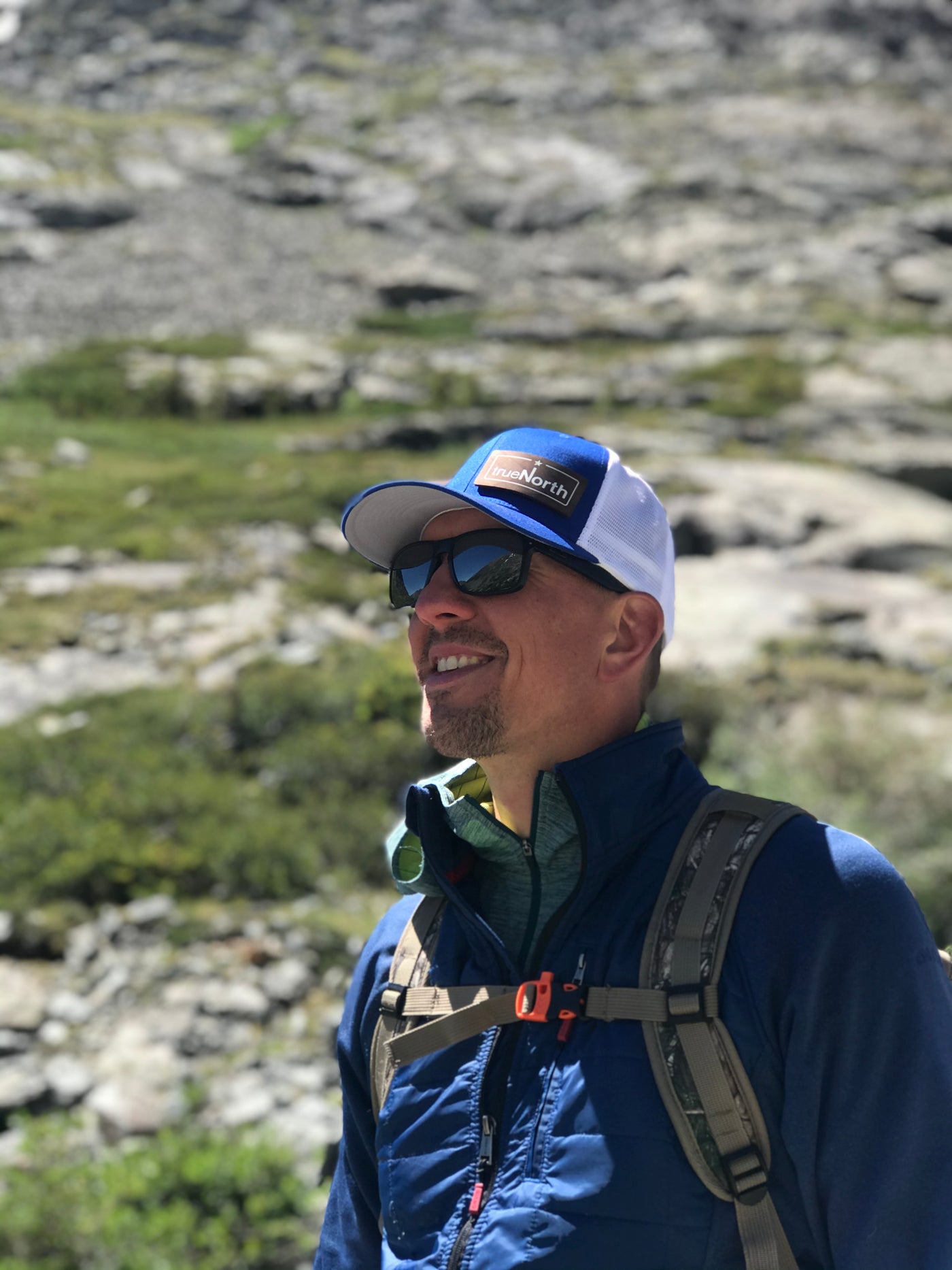 Hiker wearing a true North hat on a mountain trail